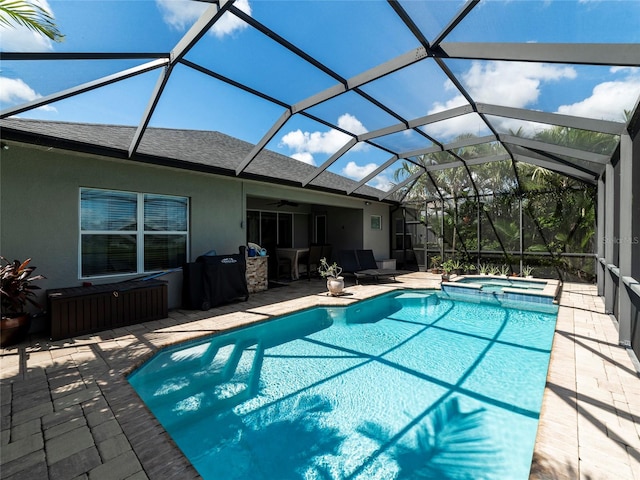 view of swimming pool featuring a patio area, an in ground hot tub, ceiling fan, and a lanai