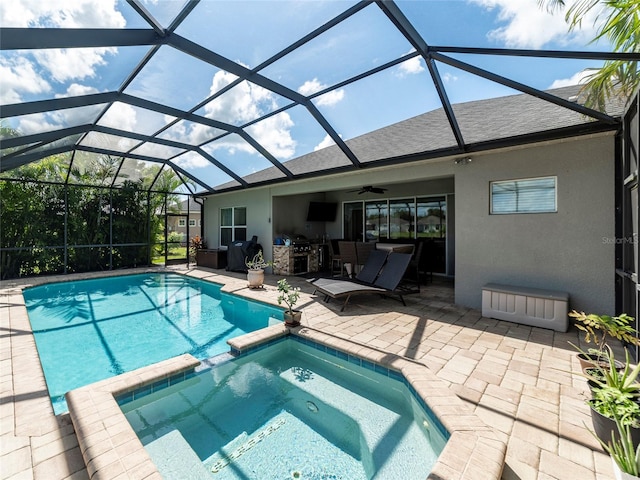 view of swimming pool with ceiling fan, a lanai, an in ground hot tub, and a patio area