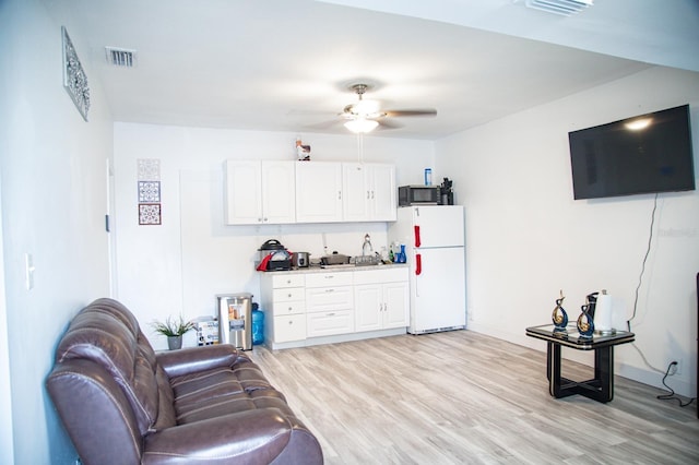 living room with light hardwood / wood-style flooring and ceiling fan