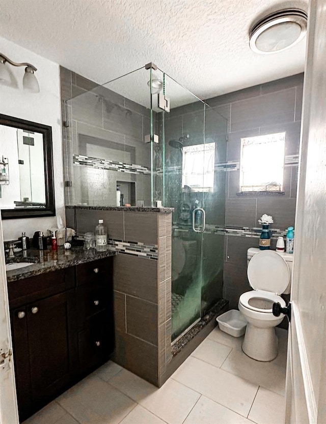 2503 W Marquette Ave, Tampa, FL 33614 - full bathroom featuring vanity, tile patterned floors, toilet, a shower stall, and a textured ceiling