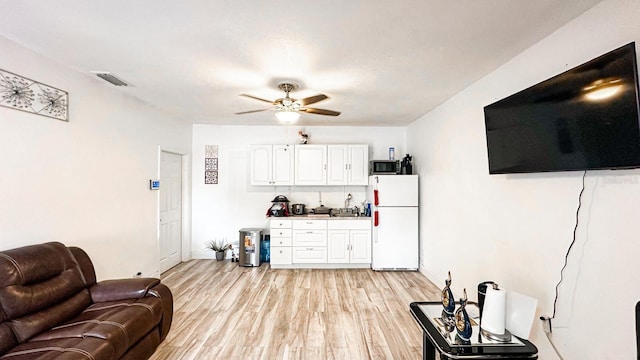 living room with ceiling fan and light hardwood / wood-style floors