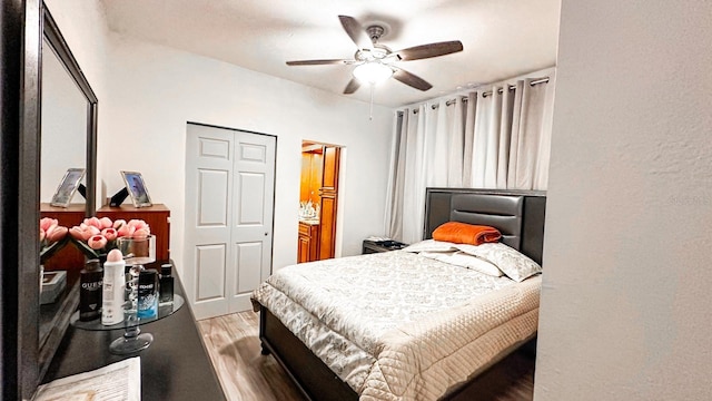 bedroom with hardwood / wood-style floors, ceiling fan, and a closet