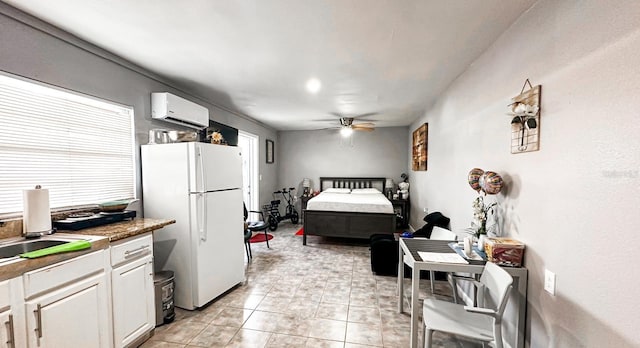 bedroom featuring light tile patterned floors, a wall mounted air conditioner, and white fridge