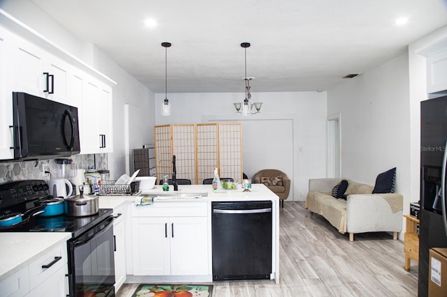 kitchen with black appliances, light hardwood / wood-style floors, hanging light fixtures, decorative backsplash, and white cabinets