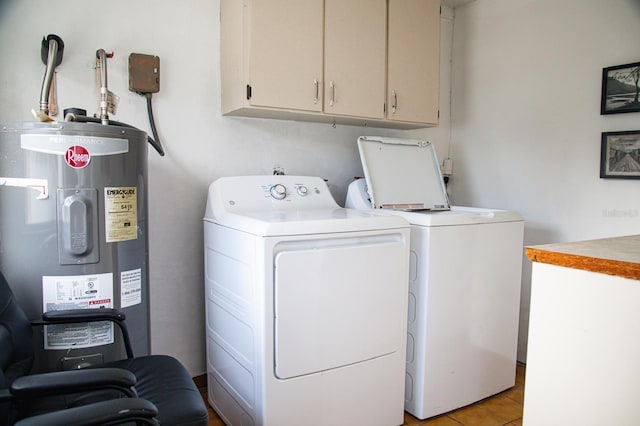 laundry area with electric water heater, light tile patterned floors, cabinets, and washing machine and clothes dryer