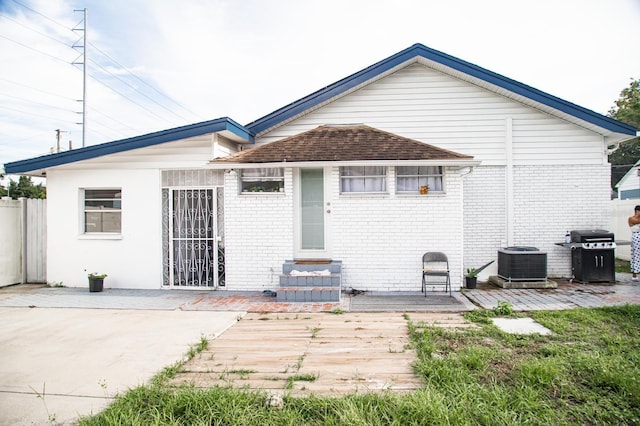 2503 W Marquette Ave, Tampa, FL 33614 - rear view of house with central AC, brick siding, and a wooden deck
