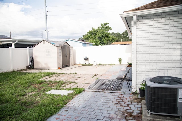 exterior space with central AC unit, a shed, and a patio