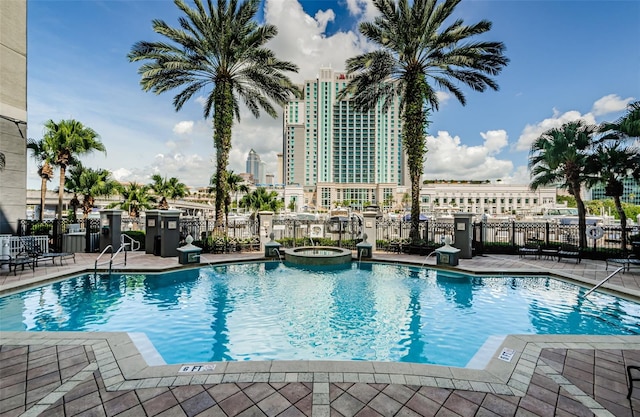 view of pool with a hot tub and a patio area