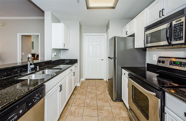 kitchen with white cabinets, stainless steel appliances, and dark stone countertops