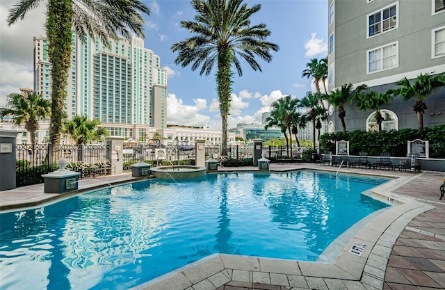 view of swimming pool featuring a hot tub and a patio