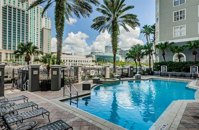 view of swimming pool with a patio area and a hot tub