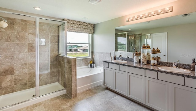 bathroom with a bath, a stall shower, double vanity, and a sink