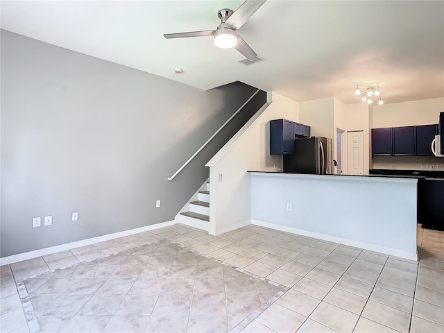 unfurnished living room featuring ceiling fan with notable chandelier and light tile patterned flooring