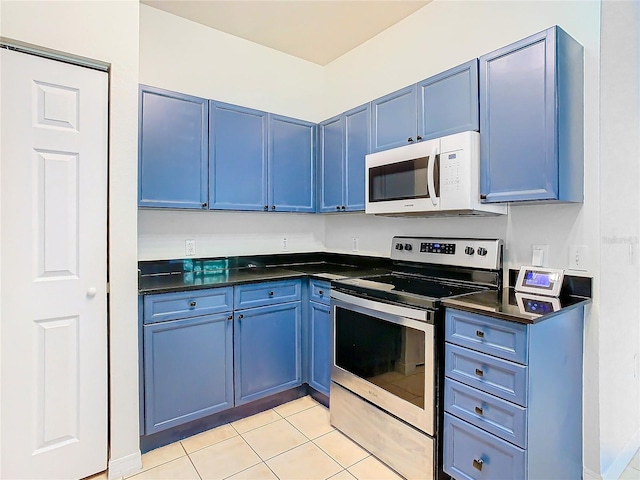 kitchen featuring stainless steel electric stove, light tile patterned flooring, and blue cabinetry