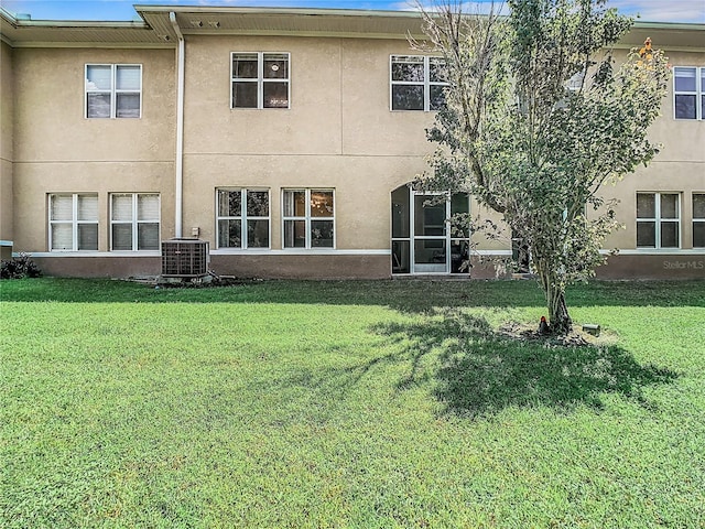 back of house with a yard and central AC