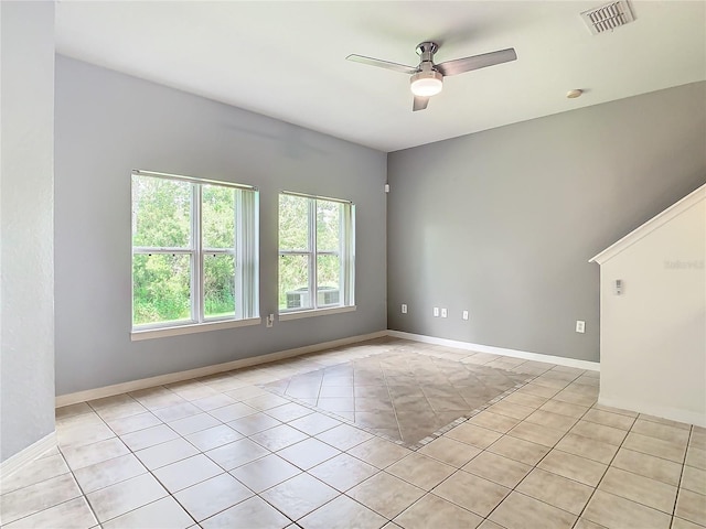 tiled empty room featuring ceiling fan