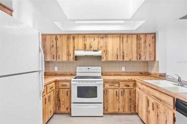 kitchen with light wood-type flooring, white appliances, decorative backsplash, and sink