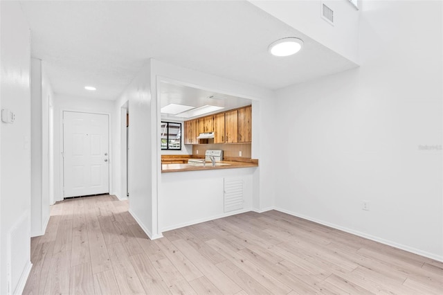 kitchen featuring white electric range and light hardwood / wood-style floors