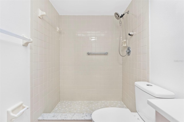 bathroom with toilet and a tile shower