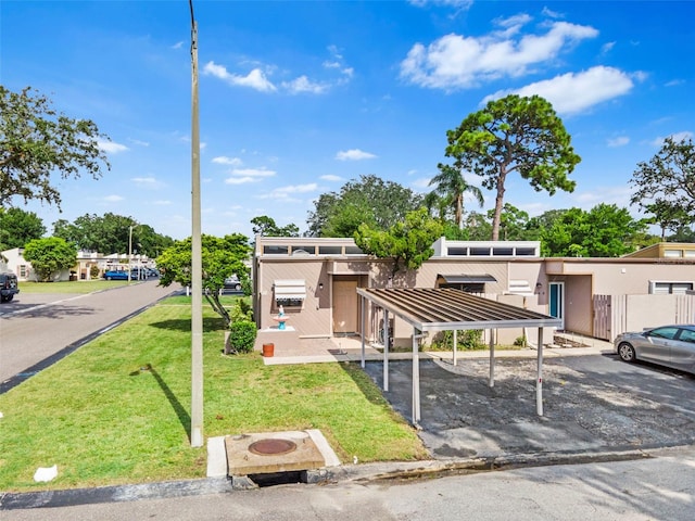 view of front of home with a front yard and a carport