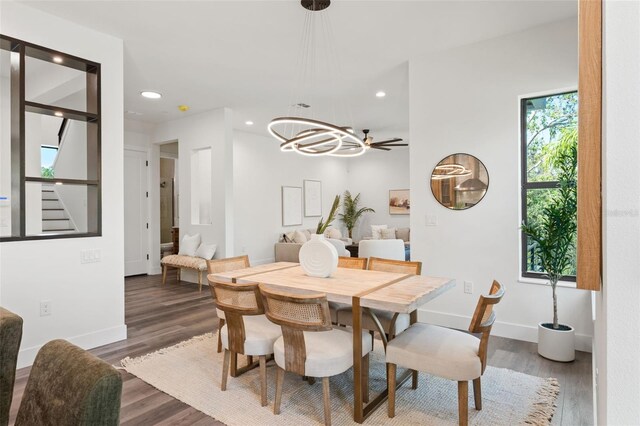 dining area with dark hardwood / wood-style flooring and ceiling fan with notable chandelier