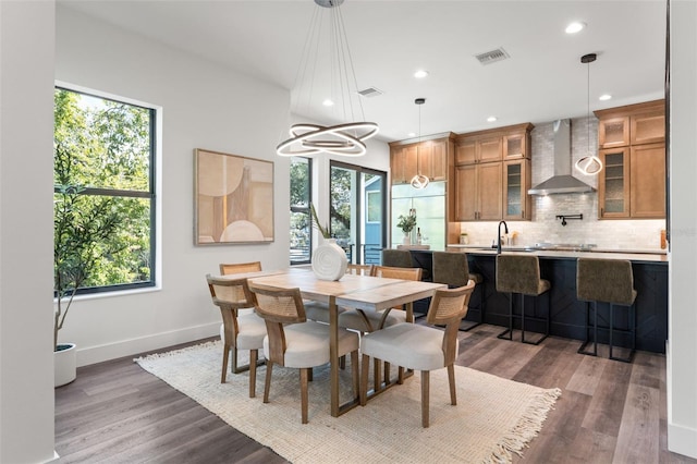 dining area featuring a wealth of natural light, wood finished floors, and visible vents