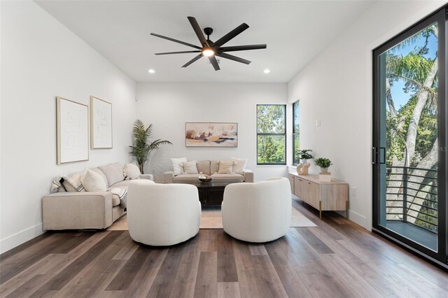 living room with ceiling fan and dark hardwood / wood-style flooring