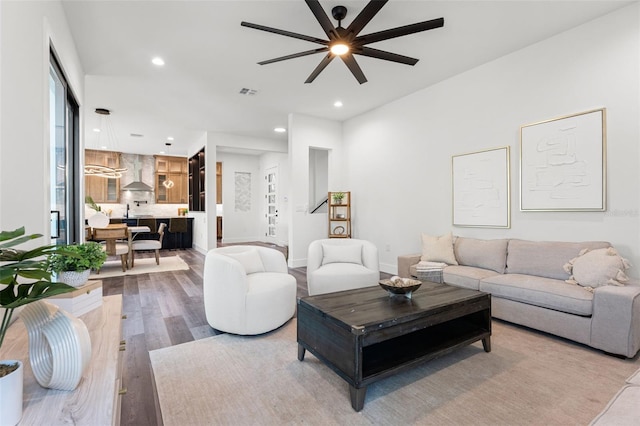 living area featuring baseboards, visible vents, ceiling fan, wood finished floors, and recessed lighting