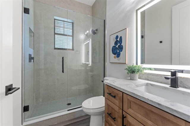 bathroom featuring toilet, a shower with door, hardwood / wood-style flooring, and vanity