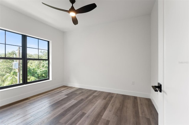 spare room with a ceiling fan, baseboards, and wood finished floors