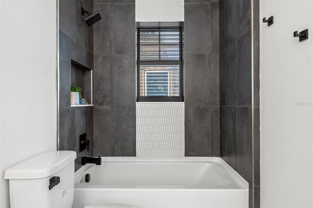 bathroom featuring toilet and tiled shower / bath