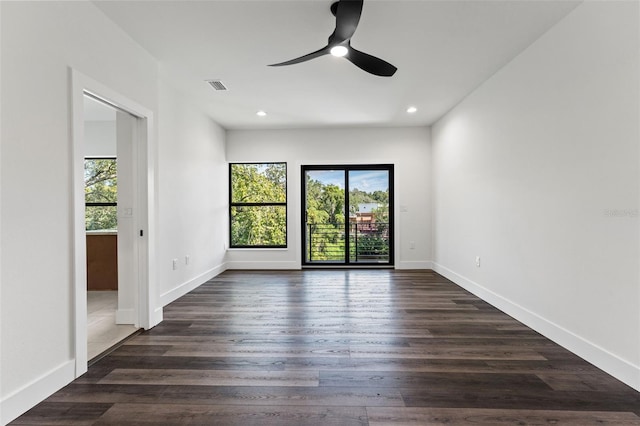 empty room featuring recessed lighting, dark wood finished floors, visible vents, and baseboards