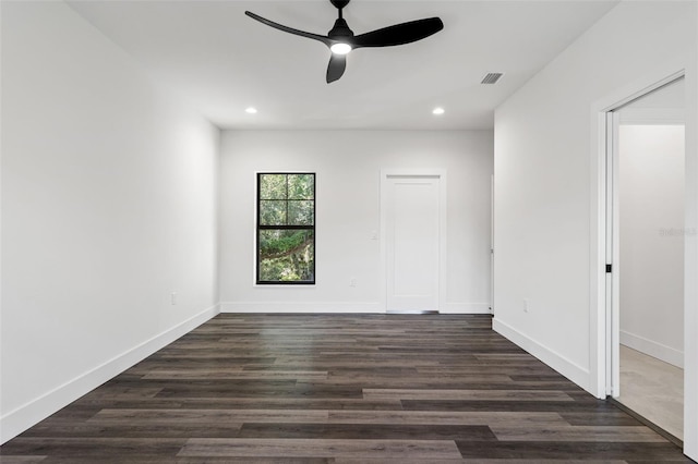 empty room featuring dark wood-style floors, baseboards, visible vents, and recessed lighting