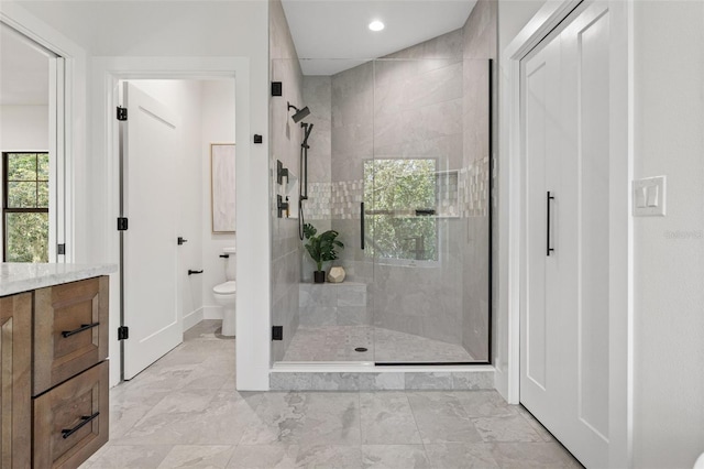 full bath featuring marble finish floor, a stall shower, vanity, and toilet