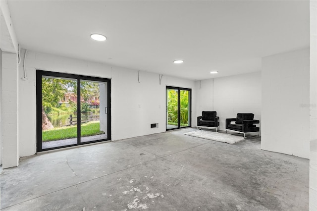 interior space with concrete block wall and unfinished concrete floors