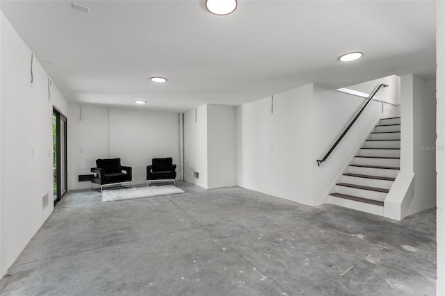 basement featuring stairs and concrete block wall