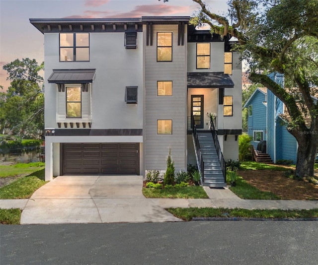 view of front of home featuring driveway, a garage, stairway, and stucco siding