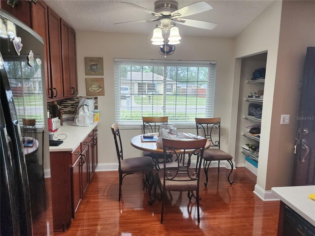 dining room featuring a textured ceiling, ceiling fan, built in shelves, and dark hardwood / wood-style flooring