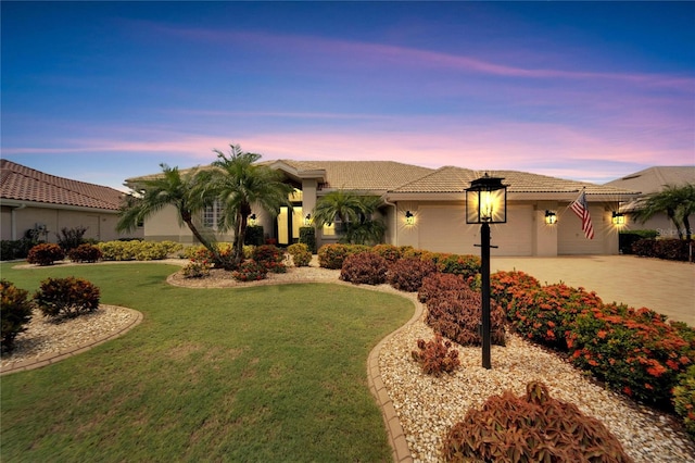 mediterranean / spanish house with a lawn and a garage