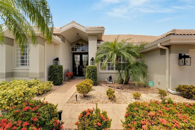 entrance to property featuring a tile roof and stucco siding