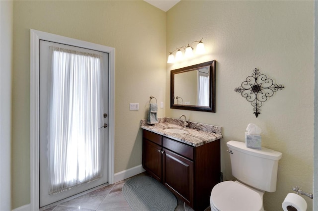 bathroom featuring tile patterned floors, vanity, and toilet