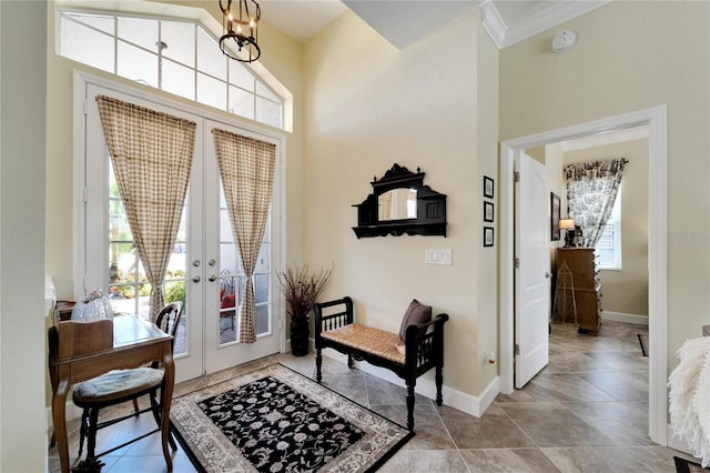 foyer entrance featuring a wealth of natural light, crown molding, a chandelier, and french doors