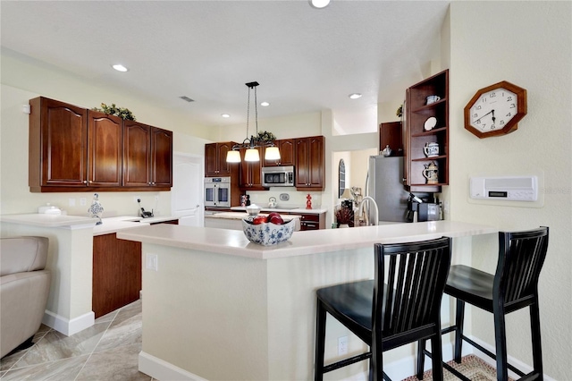 kitchen with kitchen peninsula, decorative light fixtures, a breakfast bar, and stainless steel appliances