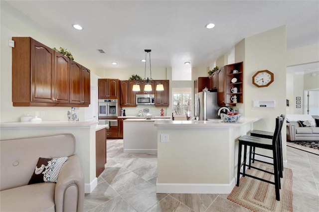 kitchen featuring kitchen peninsula, a breakfast bar, stainless steel appliances, and hanging light fixtures