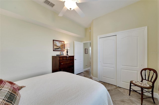 tiled bedroom featuring a closet, lofted ceiling, and ceiling fan