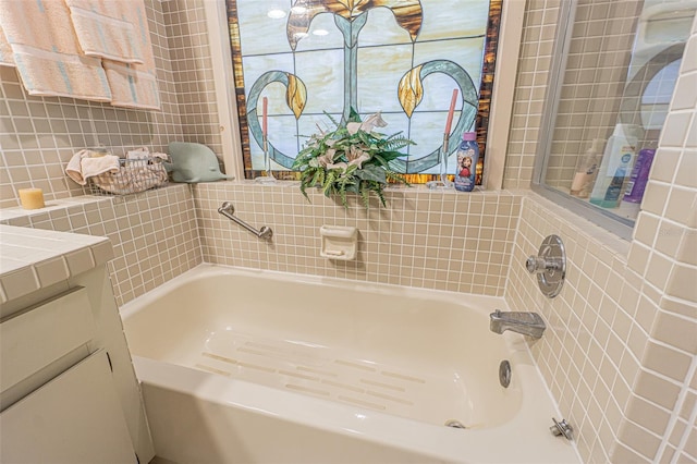 bathroom featuring a bath, tile walls, and vanity