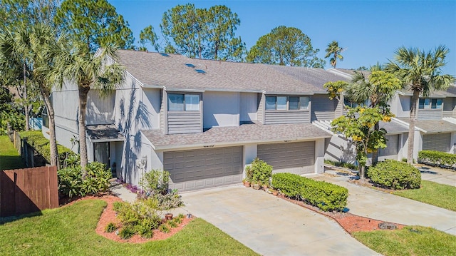 view of property featuring a front lawn and a garage