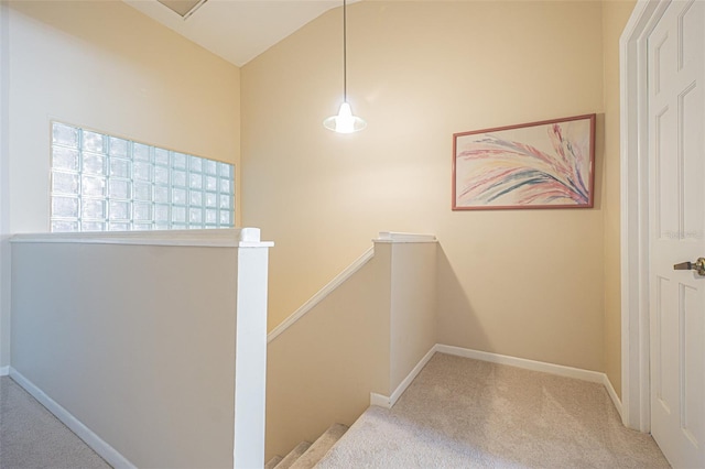 hall with lofted ceiling and light carpet