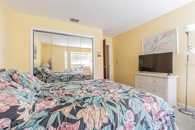 bedroom with a closet, carpet, and a textured ceiling