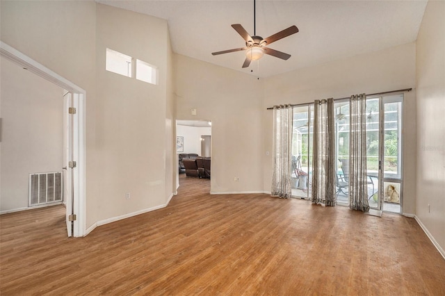 unfurnished living room featuring light hardwood / wood-style flooring, ceiling fan, and high vaulted ceiling